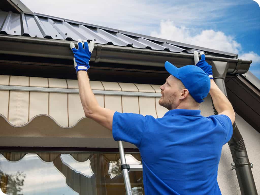 a person installing gutter on roof
